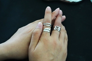 Close-up of three layered vintage silver open rings with crossover and wavy designs