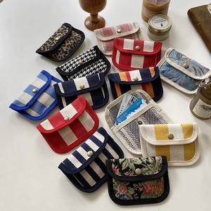 Close-up of canvas coin purses with various patterns and vintage bronze snap buttons