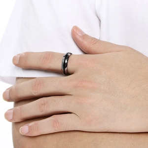 Dettaglio dell'anello sfaccettato nero e argento indossato sulla mano del modello
