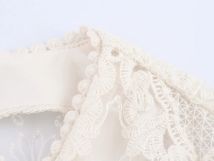 Dettaglio di elegante pizzo color crema con ricamo delicato e particolari in mesh