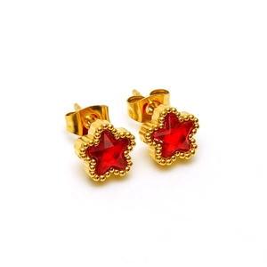 Close-up of gold star earrings with red zircon stones and detailed beaded edges
