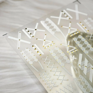 3D embossed nail stickers with white lace and gold accents on a transparent sheet
