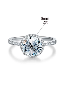 Detail view of 2ct 8mm round moissanite ring with halo setting and accent stones