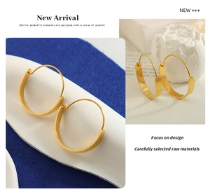 Detail view of chunky gold hoop earrings with flat arc design on blue velvet display