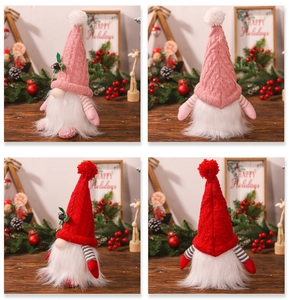 Detail view of plush Christmas gnomes with knitted hats and long beards on wood background
