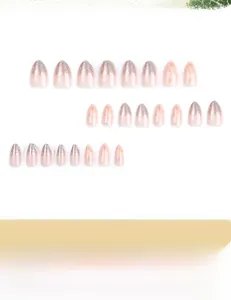 Detail view of almond-shaped pink gradient press-on nails with silver glitter and gold snowflakes