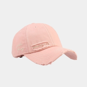 Close-up of distressed details and artistic embroidery on a pink vintage baseball cap