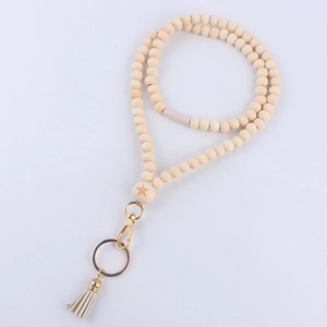 Detail of wooden bead lanyard with engraved star bead, lobster clasp, and beige tassel