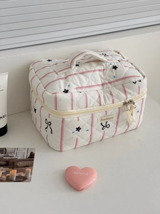 Pink star and bow quilted vanity bag with top handle shown in a bright lifestyle setting
