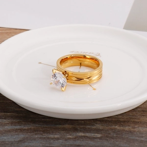 Detail of gold titanium steel ring featuring a large round zircon and geometric engravings