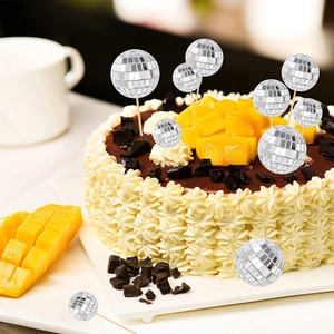 Silver mirror disco ball cake toppers in various sizes on a chocolate mango mousse cake