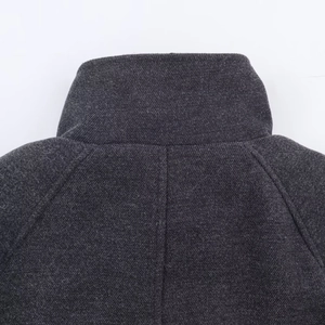 Close-up of the dark grey wool blend fabric texture and stitching on the stand collar coat