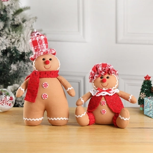 Detail of Christmas gingerbread couple plush dolls with knitted textures and festive hats