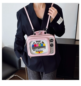 Detail view of a pink retro TV crossbody bag with signal pattern and metal knobs