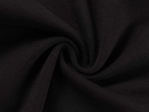 Macro detail of soft black cotton knit fabric showing fine texture and draped folds