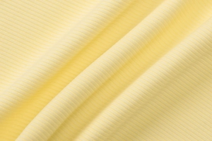 Gros plan sur la texture du tricot côtelé jaune vif montrant élasticité et douceur