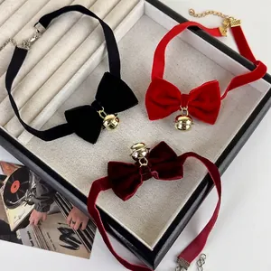 Trois colliers chokers en velours avec nœuds et cloches dorées en rouge noir