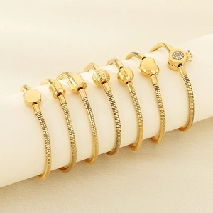 Detailed display of gold snake chain bracelets with heart and crown diamond pendants