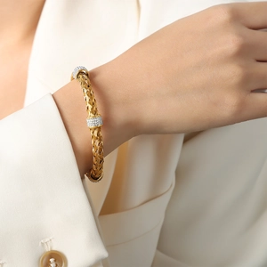 British vintage woven gold bangle with geometric diamond accents on white suit sleeve