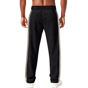 Detail view of black men's sports trousers showing breathable mesh fabric and ivory side stripes