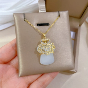 Detail of gold titanium steel necklace with crystal diamonds and white jade pendant