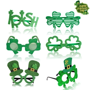 Flat lay of 6 green St. Patrick's Day party glasses with clover and glitter designs