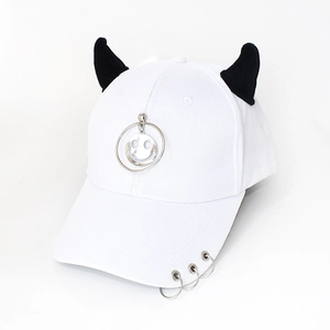 Close-up of white baseball cap featuring black demon horns and silver metal ring accents