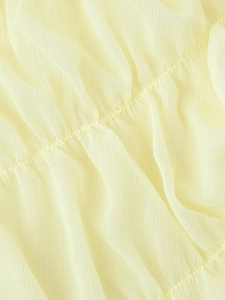 Detailed close-up of pale yellow pleated chiffon fabric with intricate ruffled stitching