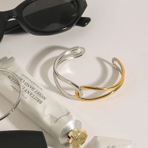 Two-tone gold and silver titanium steel open bangle with a polished metallic finish