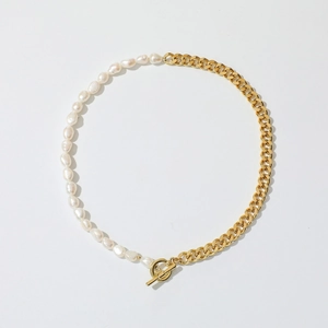 Detail of half baroque pearl and half gold Cuban chain necklace with a toggle clasp