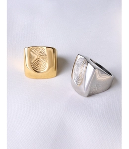 Makroaufnahme goldener und silberner Titanringe mit einzigartiger Fingerabdruck-Gravur