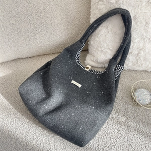 Dettaglio della borsa tote in feltro grigio scuro con paillettes a stella e fodera