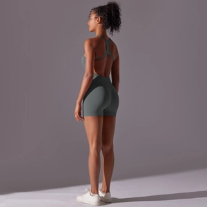 Detail of grey-green yoga bodysuit showing racerback cutout and seamless fitted shorts