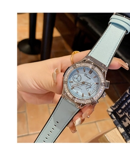 Détail d'une montre à quartz pour femme avec bracelet bleu clair et lunette en diamants