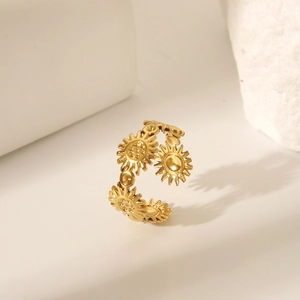 Detailed view of a gold sunflower open ring on a textured stone display for a luxury look
