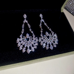 Close-up of luxury silver drop earrings with zircons on black velvet box