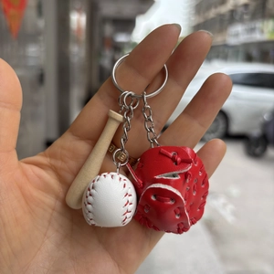Detailed view of mini baseball bat, ball and red glove keychain held in hand