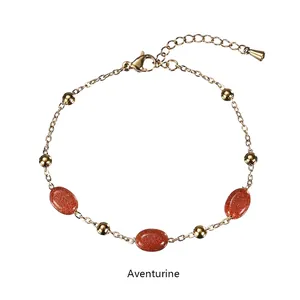 Detail view of 18K gold chain bracelet featuring red aventurine stones and clasp