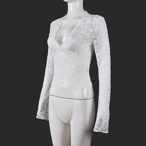 Detail of white lace texture and sheer floral patterns on a deep V-neck long sleeve top