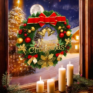 Detailed Christmas wreath with gold bells, red bows and angel charms on a snowy window