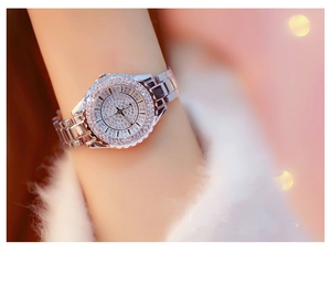 Close-up of a luxury silver rhinestone watch for women worn on a wrist with bokeh background