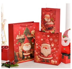 Three sizes of red Santa Claus gift bags with handles and festive fireplace illustrations