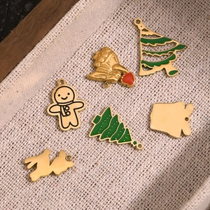 Detail of Christmas charms including gingerbread man and tree on beige linen tray