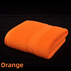Detail view of the soft orange cotton bath towel with textured woven decorative border