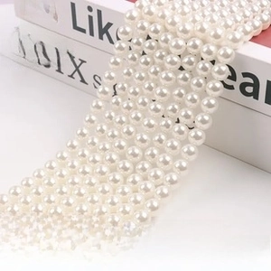 Close-up of high-luster white round pearls arranged neatly on a vintage book