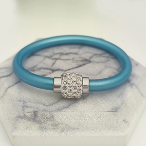 Detail von seeblauem Silikonarmband mit zylindrischem Magnetverschluss und Pavé-Kristallen