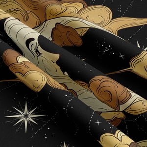 Close-up of golden moon and star constellations printed on thick black fabric texture