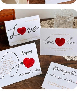 Close-up of 3D pop-up heart greeting cards with vintage envelopes on a wooden desk