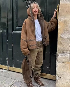 Dettaglio di una giacca marrone con cappuccio in shearling sintetico e bottoni alamari
