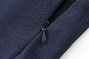 Detailed view of the invisible zipper and diagonal twill texture on navy blue top